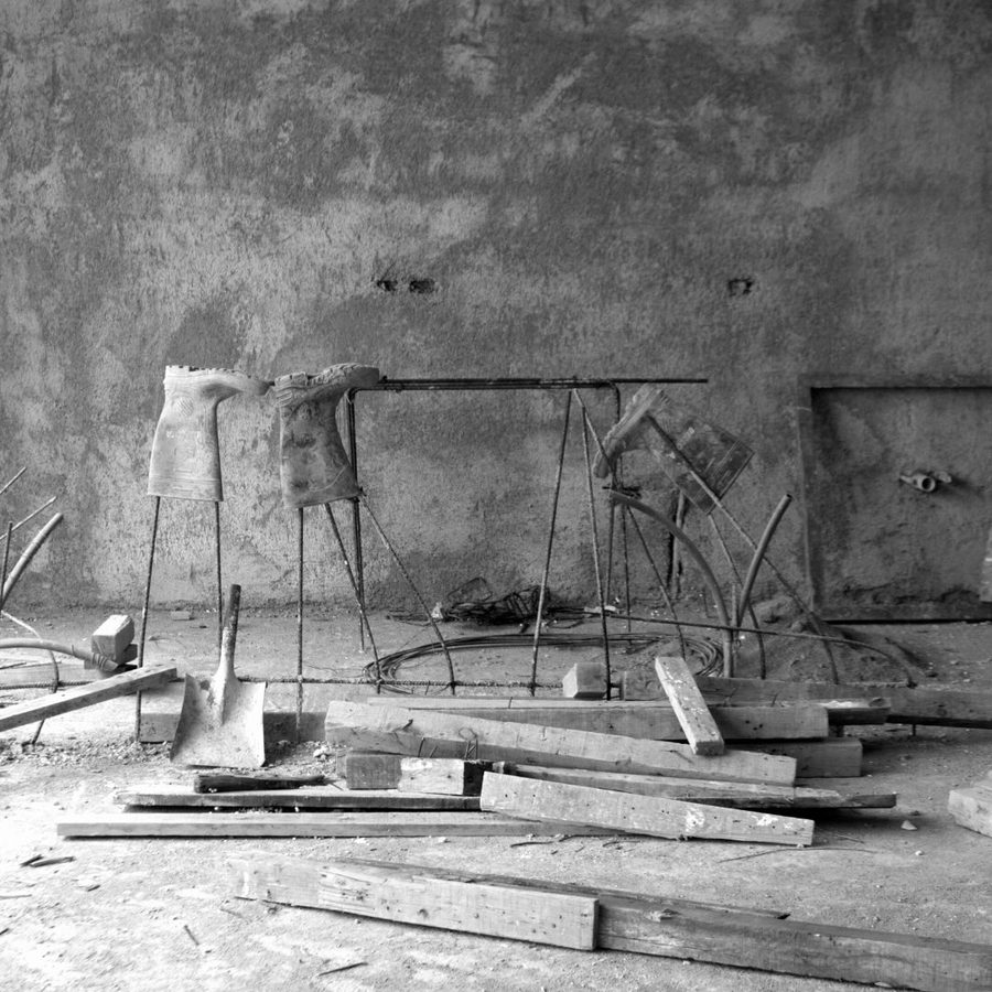 Obra en blanco y negro: carretilla y madera sobre la losa.